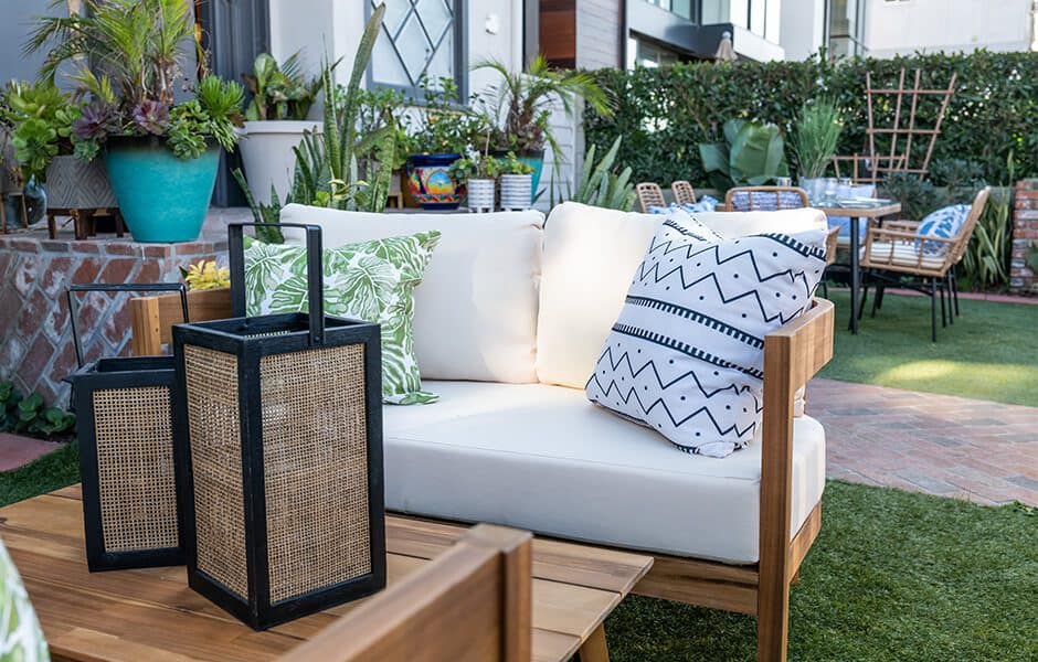 A cozy outdoor seating area with a white sofa and matching chairs