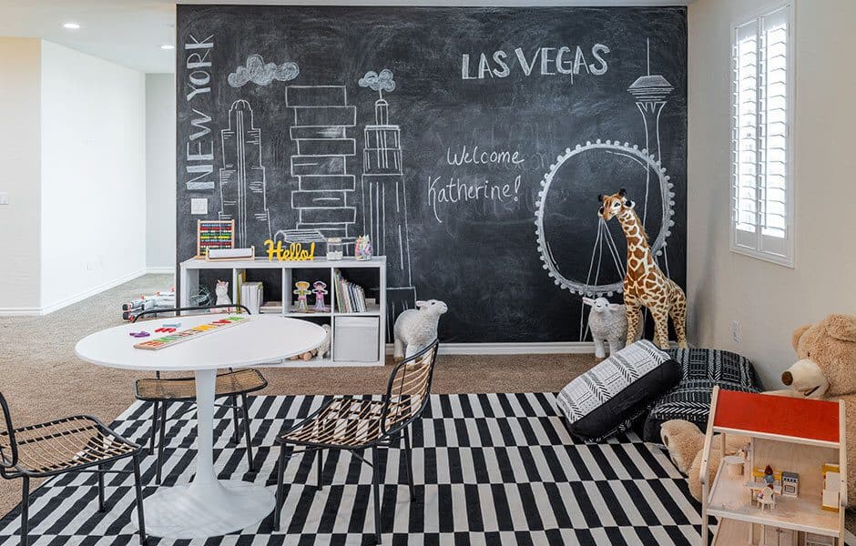 Playroom with chalkboard wall, striped rug, and plush animals