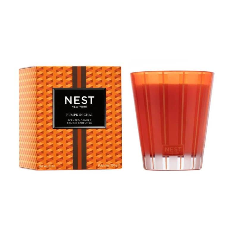 Nest New York Pumpkin Chai scented candle in an orange glass holder, displayed next to its matching patterned box