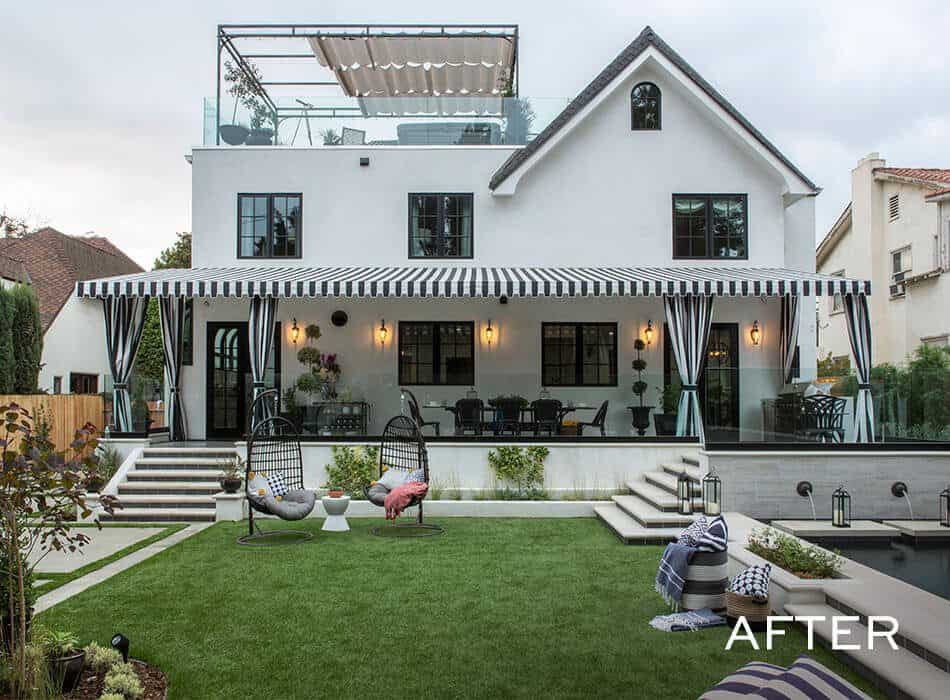 Renovated modern home with black and white striped awning, outdoor seating lush lawn, and rooftop terrace