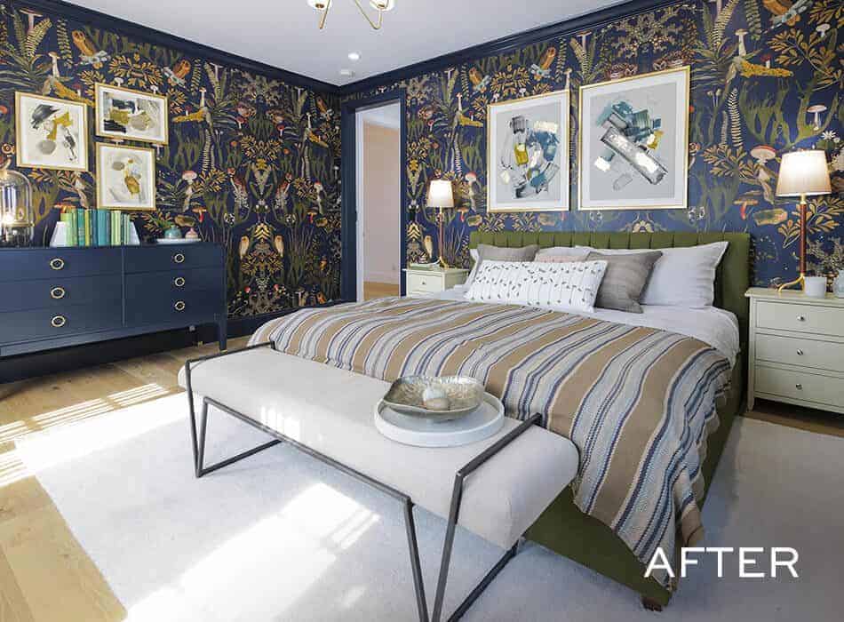 Bedroom with dark floral wallpaper, green upholstered bed, striped bedding, white nightstands, navy dresser, and framed artwork