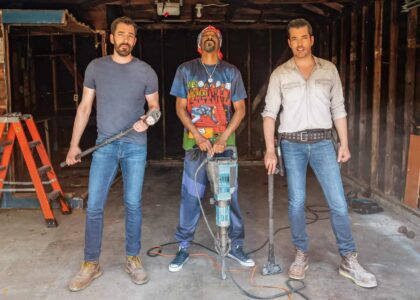 Home renovation scene with Scott brothers and Snoop Dog holding demolition tools in a partially stripped-down interior