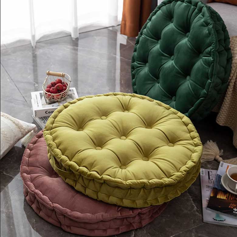 Stacked round tufted floor cushions in earthy tones