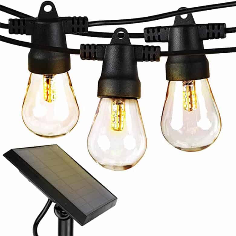 String of solar-powered LED Edison-style bulbs with black sockets and wiring, connected to a small solar panel
