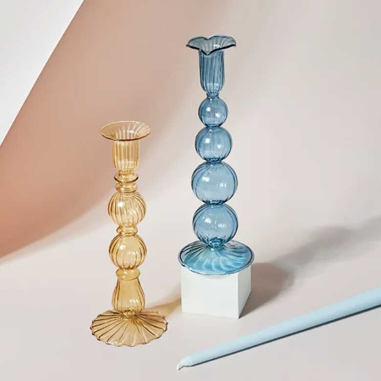 Yellow and blue ribbed glass candle holders with elegant sculptural designs