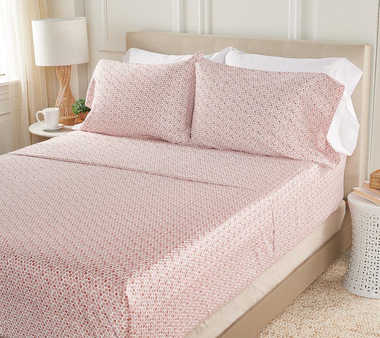 Soft pink floral bed sheets with matching pillowcases on a neatly made bed