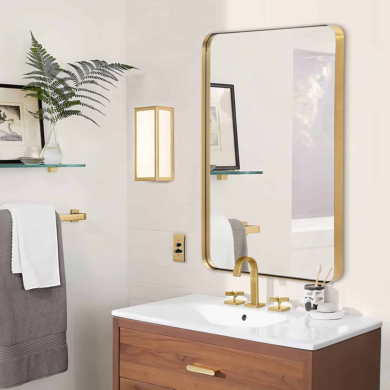 Modern bathroom with gold fixtures, wooden vanity, and large mirror