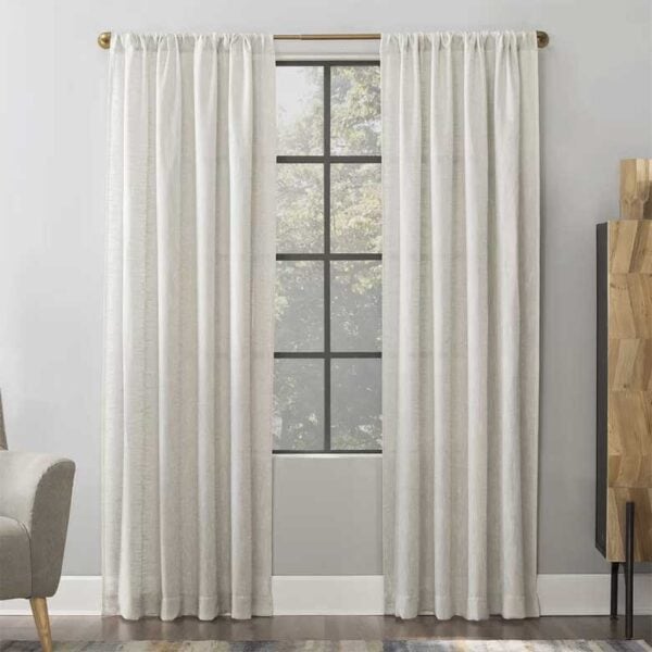 Neutral living room window with white curtains and gold curtain rod