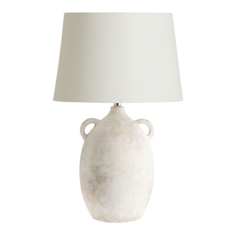 Ceramic table lamp with a textured vase-style base and a neutral fabric shade