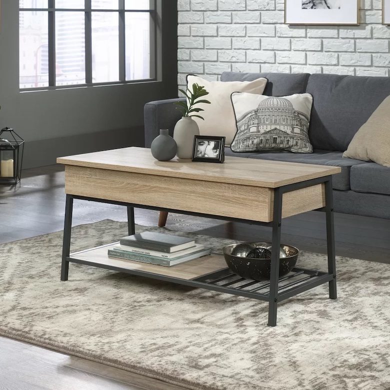 Industrial-style living room with lift-top coffee table, gray sofa, white brick wall, and decorative accents