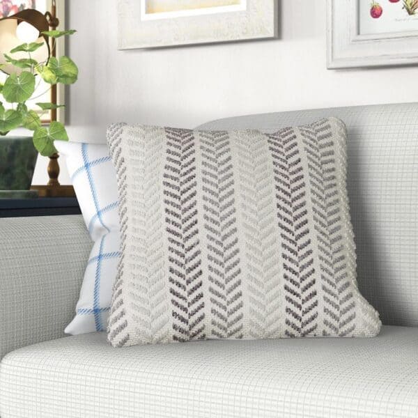 Decorative pillow with a herringbone pattern on a light gray couch