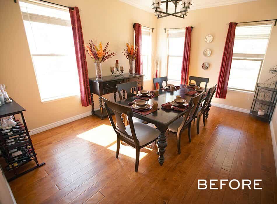 Outdated dining room with beige walls, red curtains, and a dark wooden table set for a meal