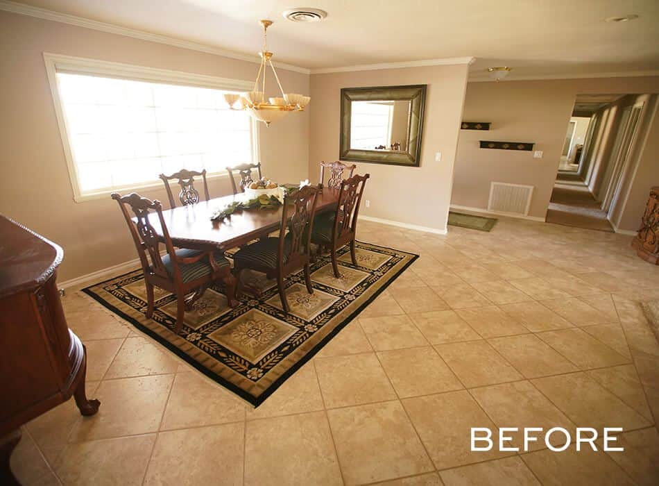 Traditional dining room with a dark wood table, decorative rug, and beige tile flooring
