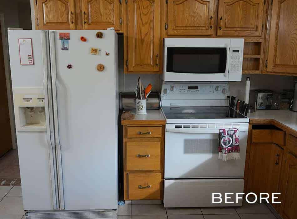 Traditional kitchen with wooden cabinets, white appliances, and tiled flooring