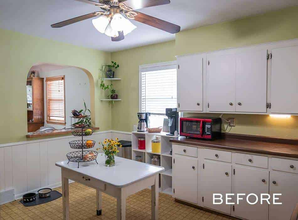 Before renovation: Small kitchen with white cabinets, yellow floors, and a curved archway