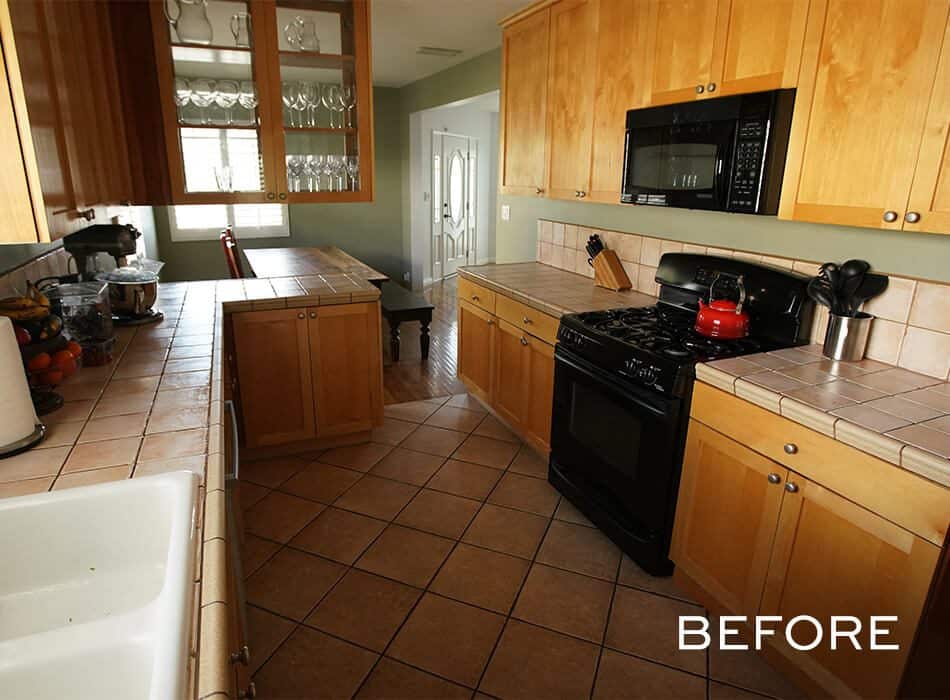 Kitchen with wooden cabinets, tiled countertops, black appliances, and a beige tiled floor