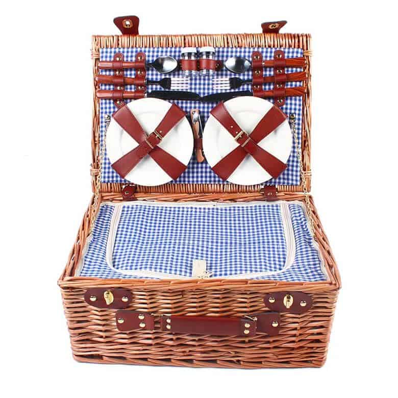 Wicker picnic basket with plates, cutlery, and blue gingham lining