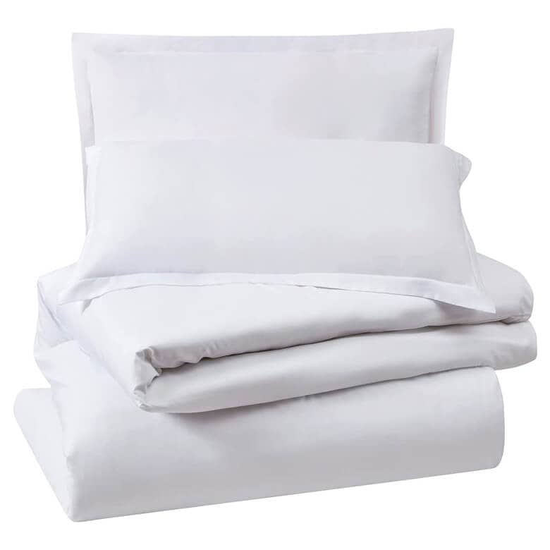White bedding set with folded sheets and pillowcases stacked neatly