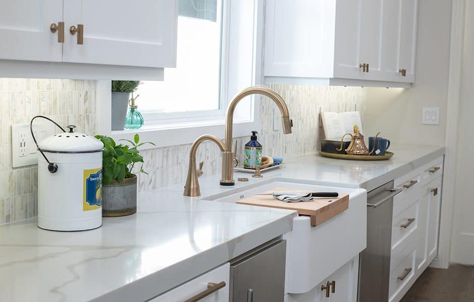 Modern kitchen featuring white cabinets, a quartz countertop, and subway tiles