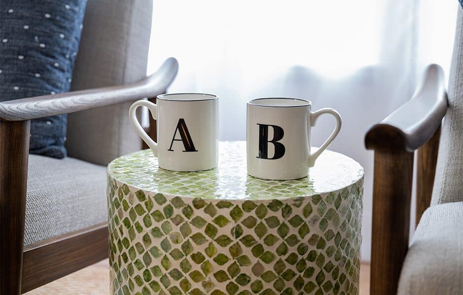 Cozy seating area with mosaic table and monogrammed mugs