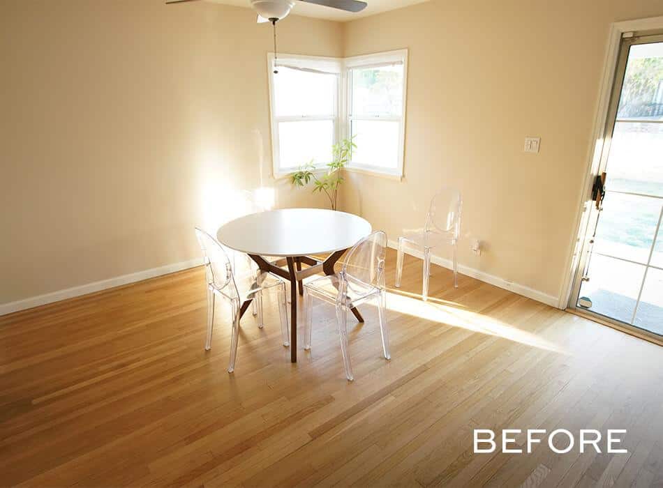 Minimalist dining area with a round white table, clear chairs, and hardwood flooring