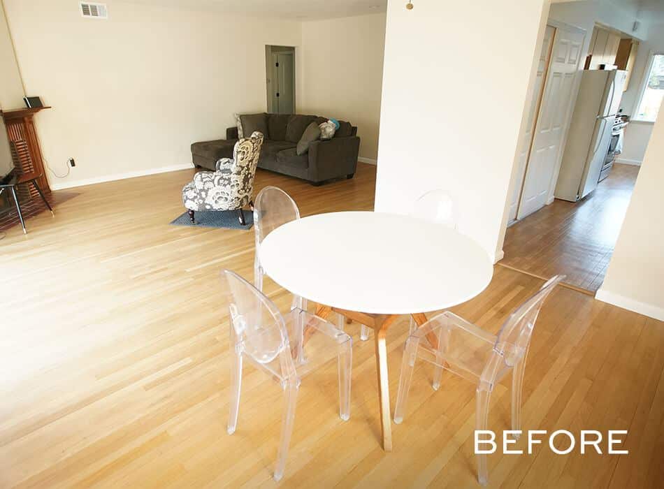 Open living space with a round white dining table, clear chairs, a gray sofa set, and hardwood floors