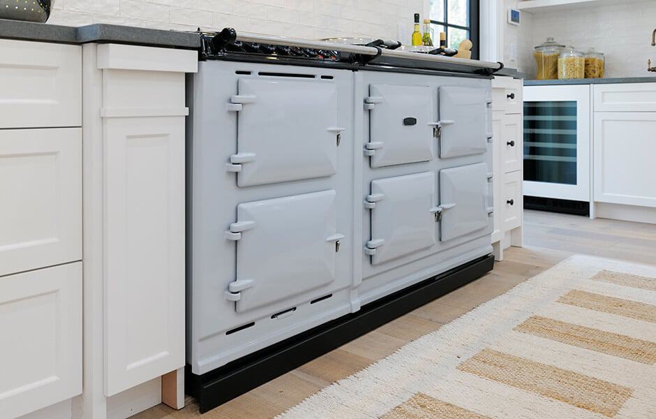 White cast-iron range cooker with multiple ovens in a modern kitchen