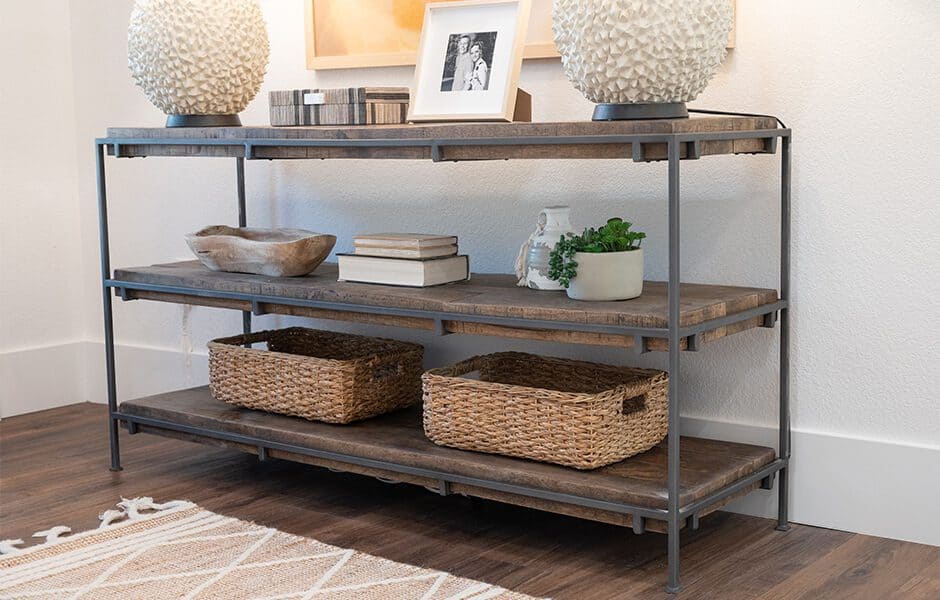 Rustic console table with woven baskets, decorative lamps, and framed photos