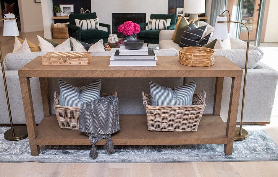 Stylish living room with wooden console table woven baskets decorative pillows and modern lamps