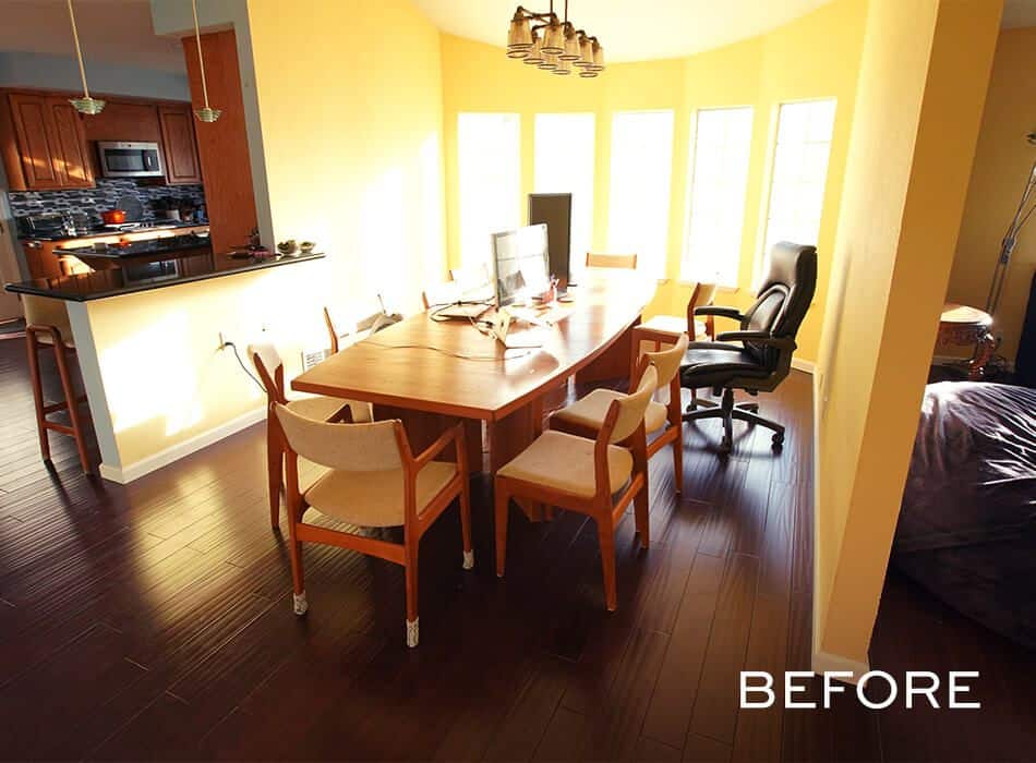 Dining room with yellow walls, wooden table, and natural light