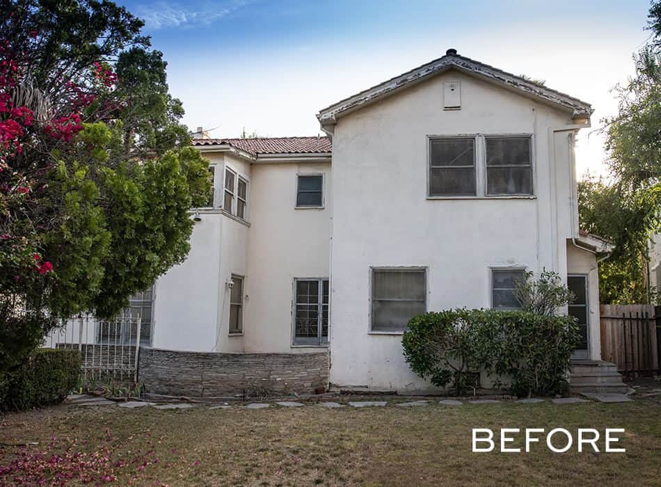 Aging two-story house with overgrown landscaping and worn exterior