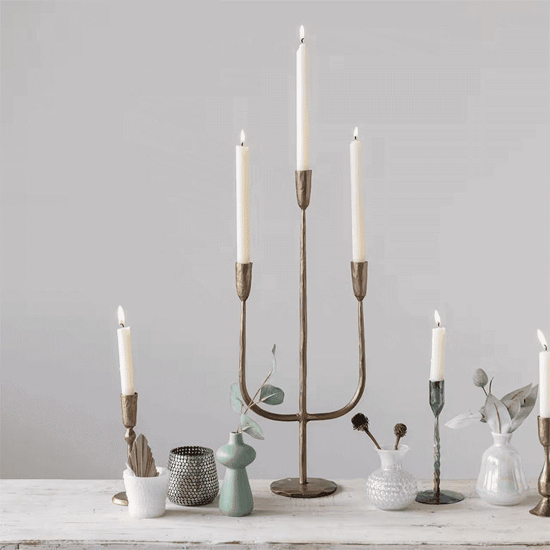 Elegant candlelit arrangement with brass candlesticks and decorative vases