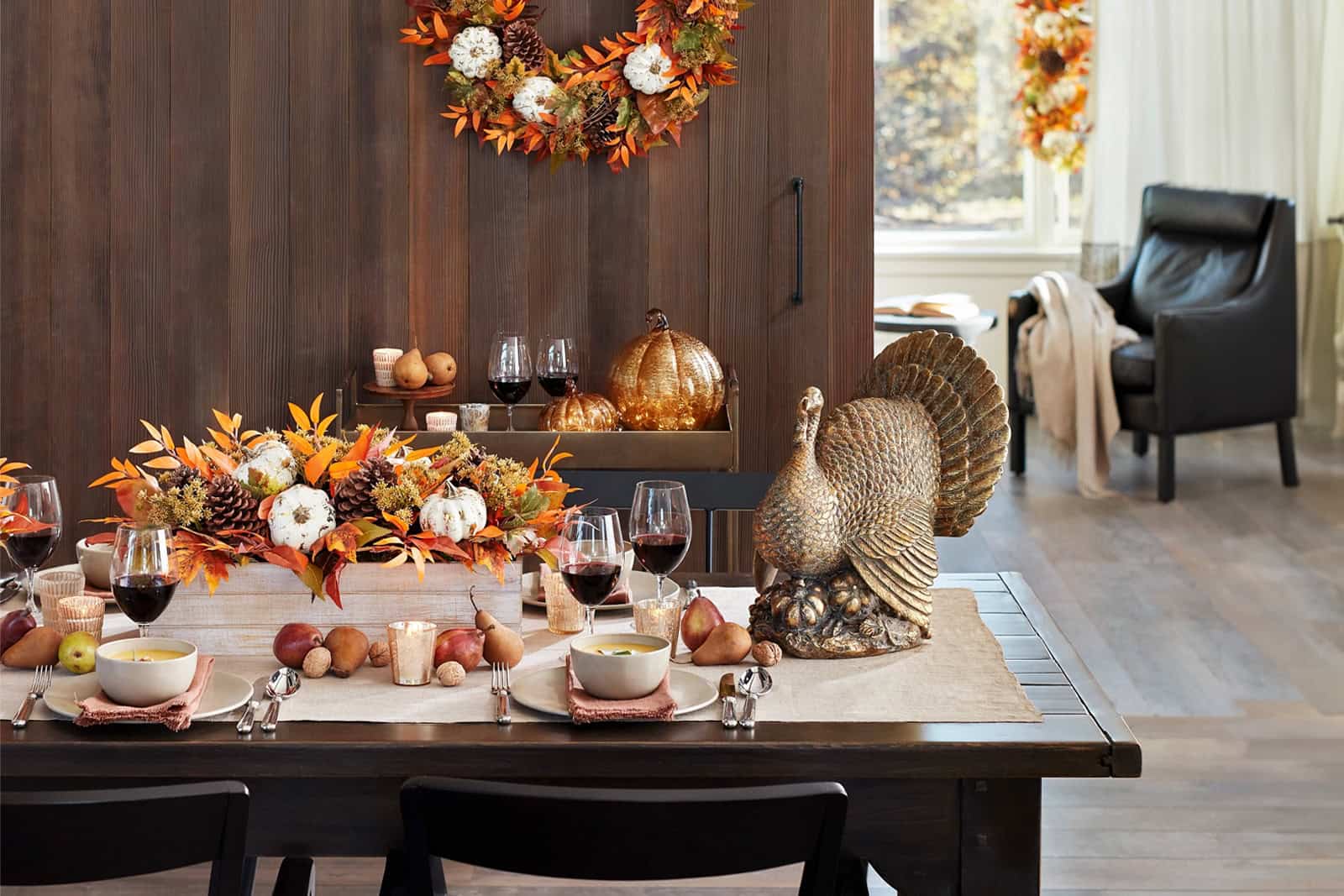 Fall-themed dining table with pumpkin centerpiece and turkey statue