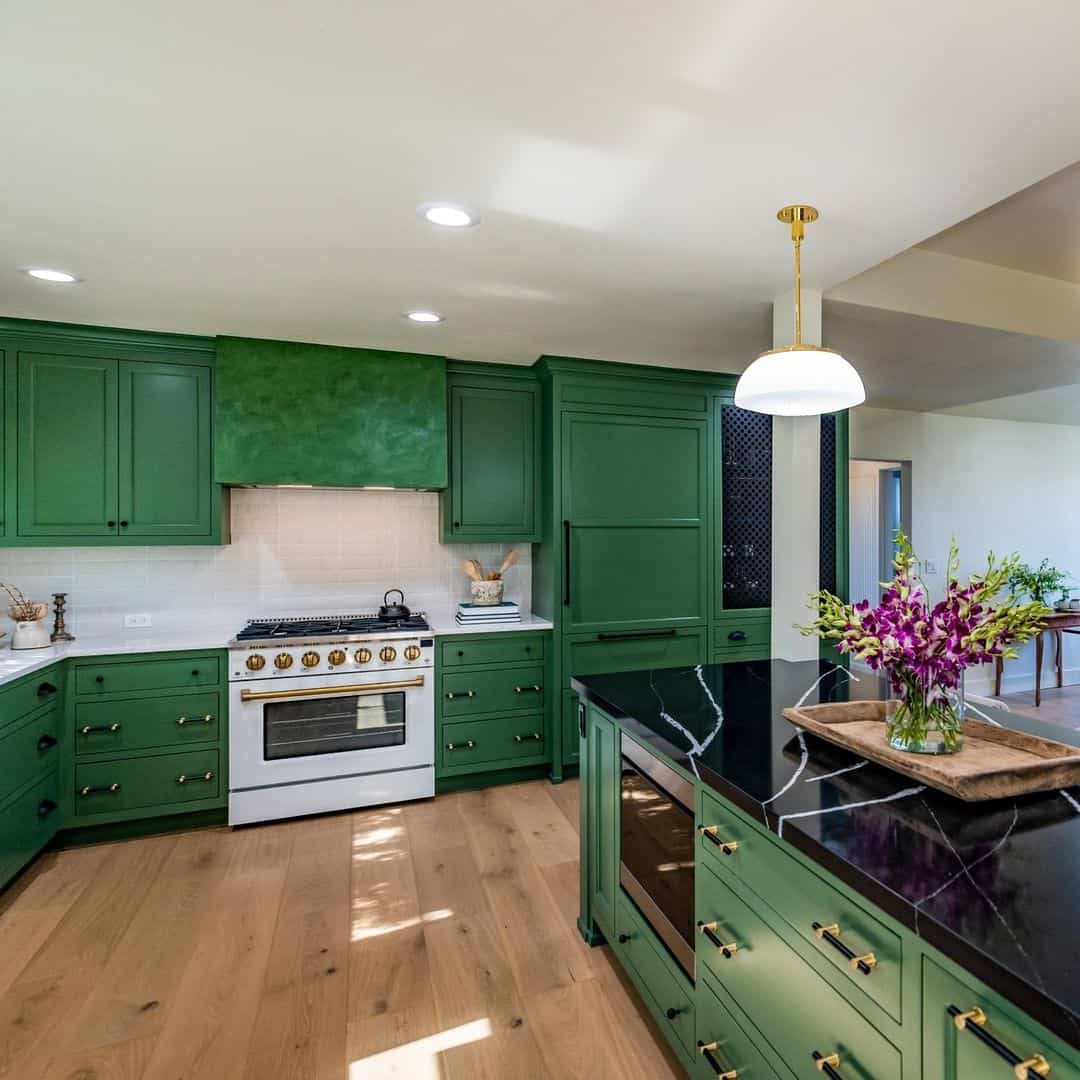 Modern kitchen with green cabinets, black countertops, and a white stove