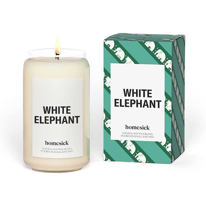Homesick “White Elephant” candle with green patterned box and lit white soy wax candle