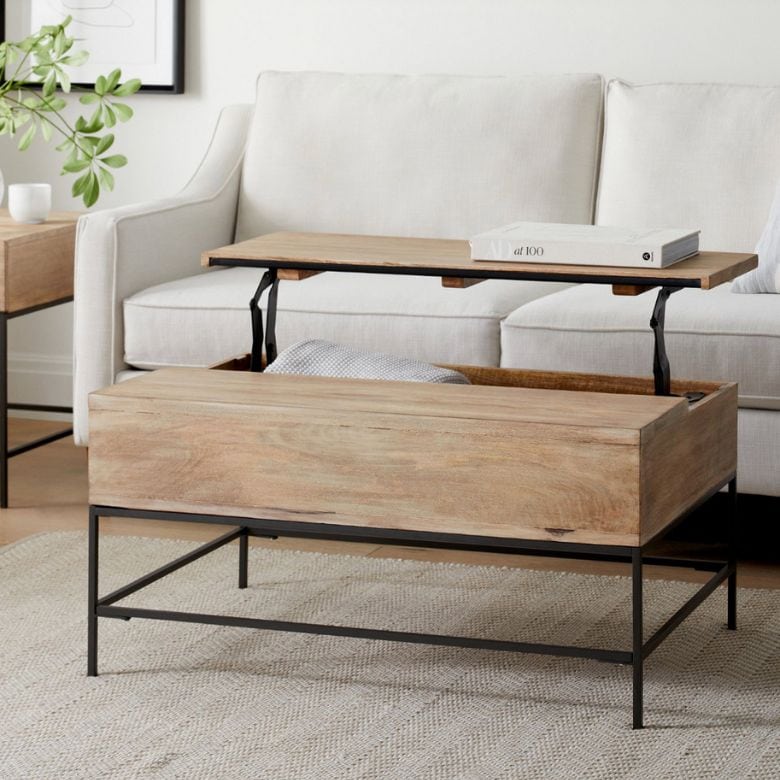 Wooden lift-top coffee table with black metal legs in front of a white sofa