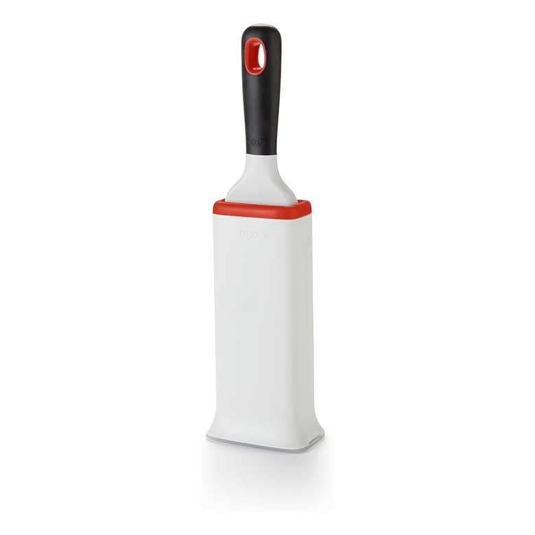 White reusable lint brush with a black handle and red trim, designed for removing pet hair from clothing.