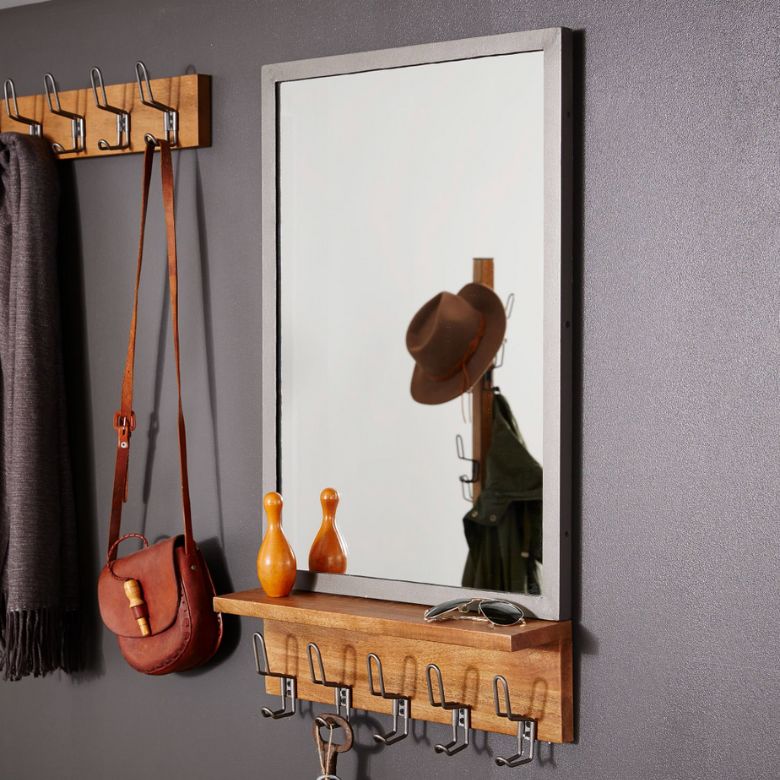 Wood-framed wall mirror with a small wooden shelf featuring metal hooks and decorative accents underneath