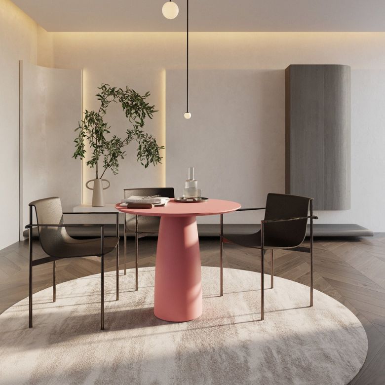 Dining room with a pink round table, black chairs, and minimalist decor