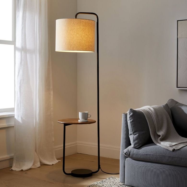 Cozy living room corner with a floor lamp featuring a built-in side table beside a gray sofa.