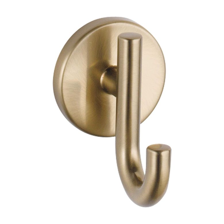 Gold wall hook with a round base and smooth curved design.