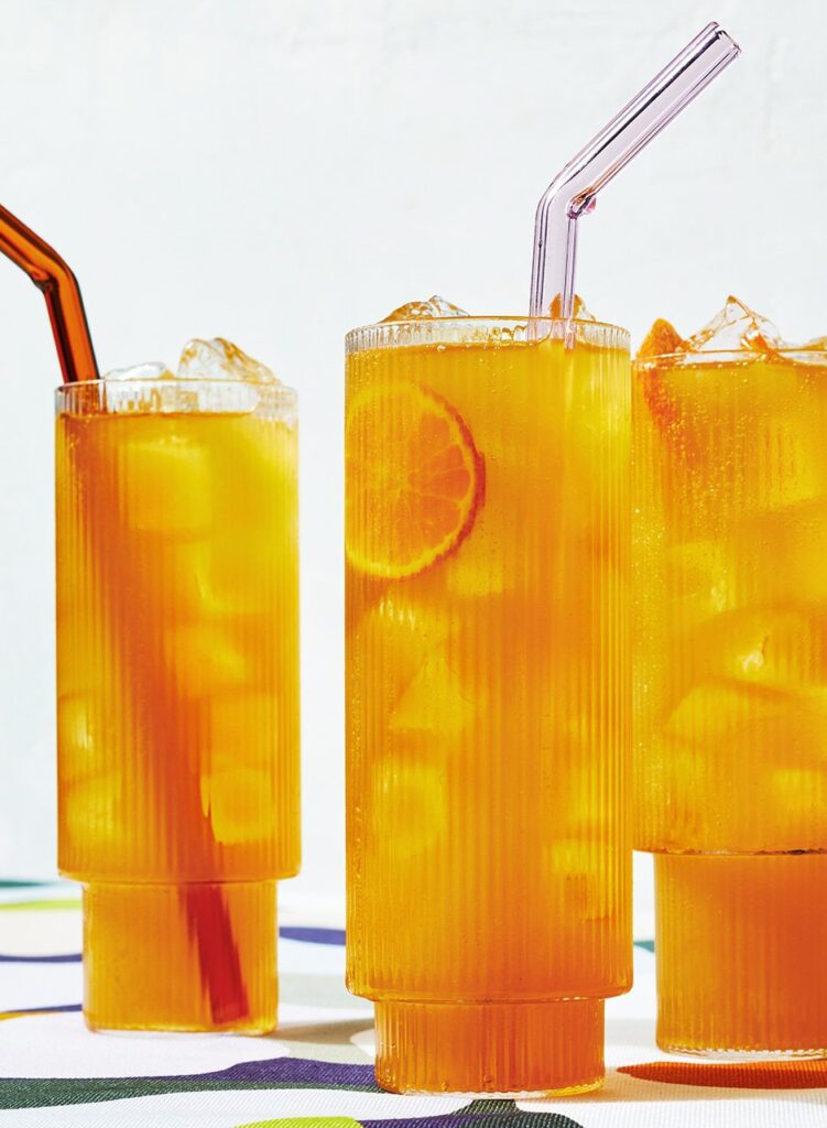 3 Tangerine Dream cocktails with straws and a tangerine wheel