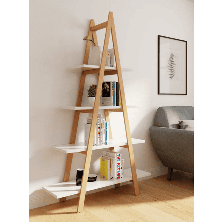 Wood and white ladder shelf holding books and decor beside a gray sofa