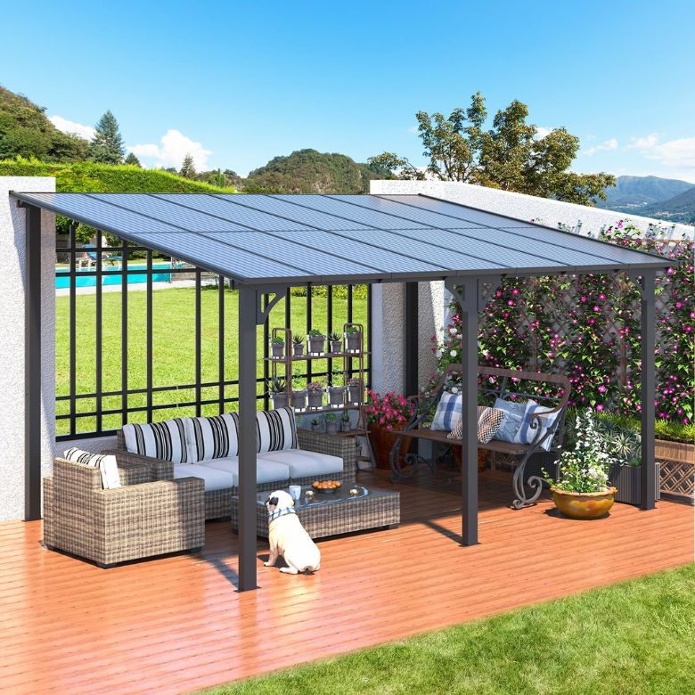 Outdoor patio with wicker furniture under a metal pergola beside a garden and lawn.