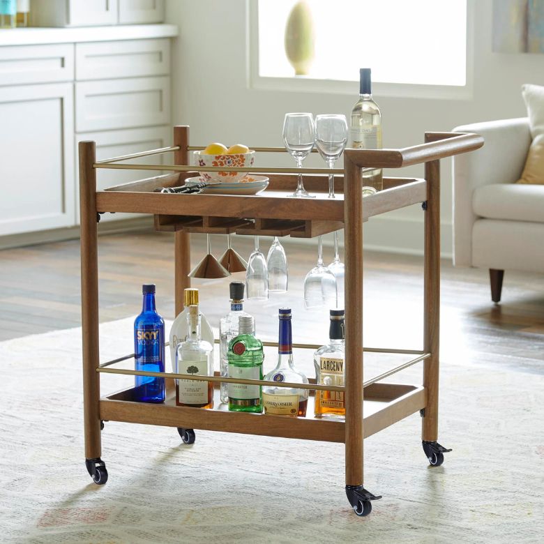 Wooden bar cart with glass holders, liquor bottles, and wine glasses on wheels