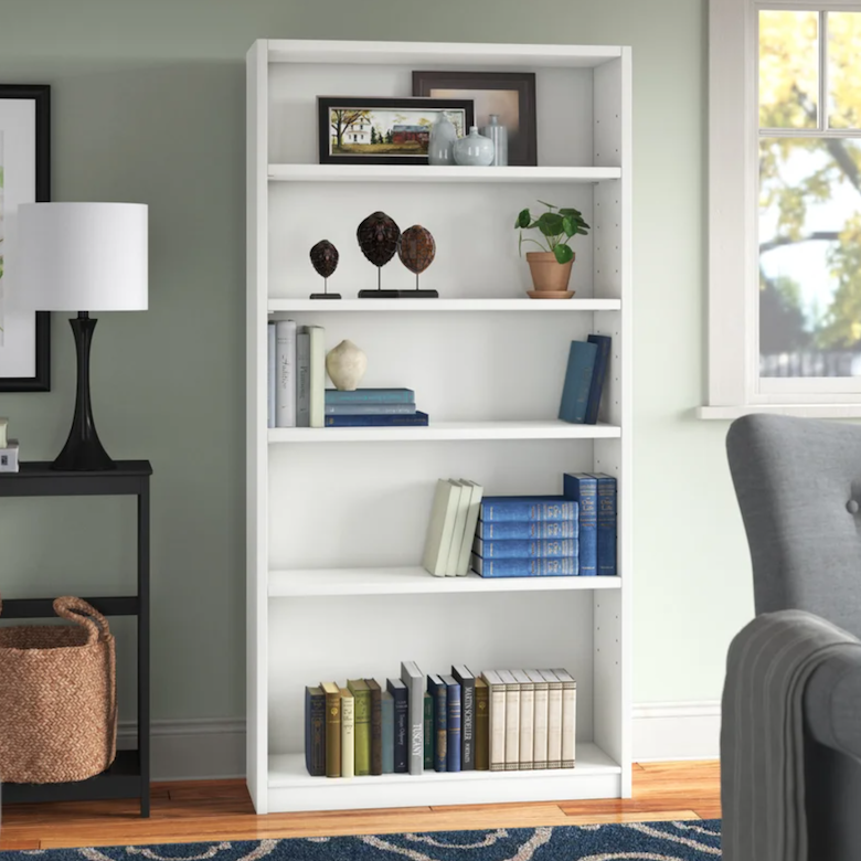White bookshelf decorated with books, framed art, and small decorative accents.