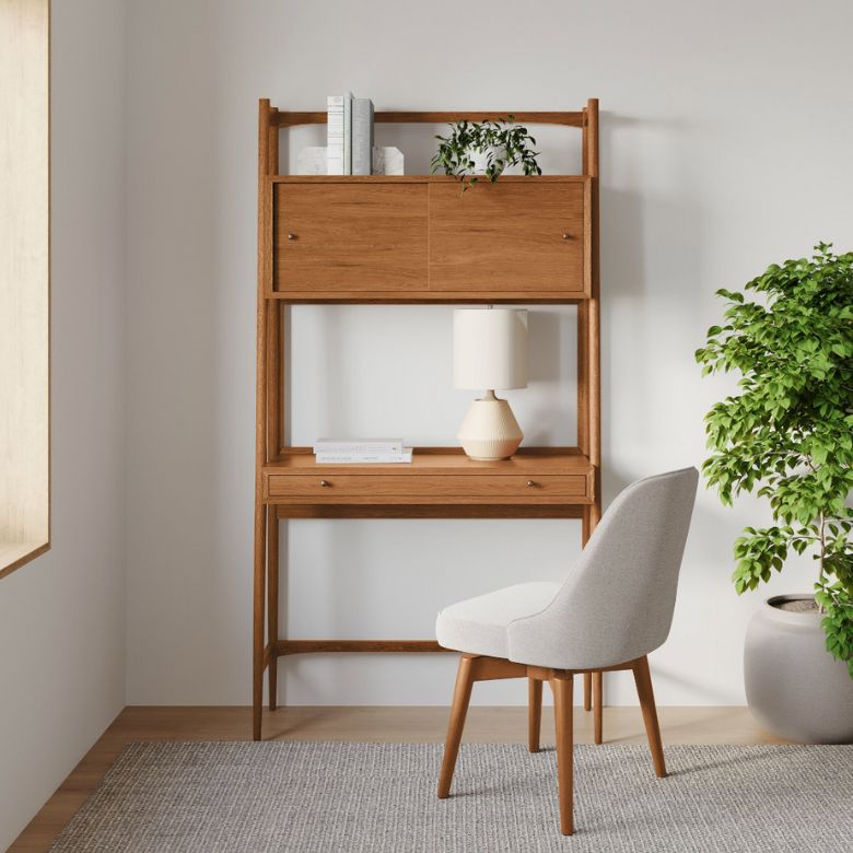 Wooden ladder-style desk with upper storage cabinets and a light upholstered chair in a bright corner.