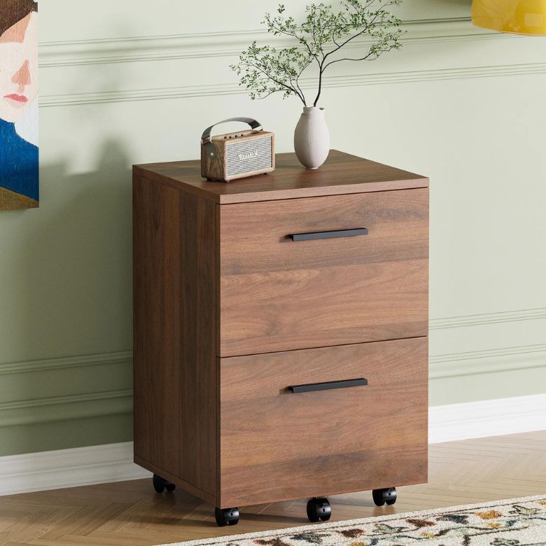 Wooden two-drawer filing cabinet on wheels with a vase and small radio on top.