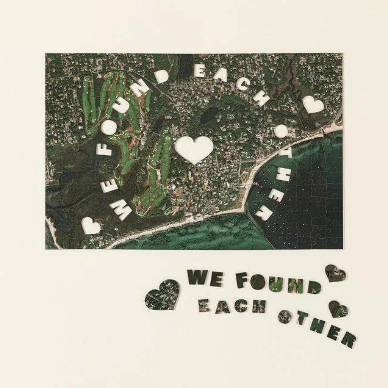 A custom photo puzzle with heart-shaped cutouts and pieces spelling “We Found Each Other.”
