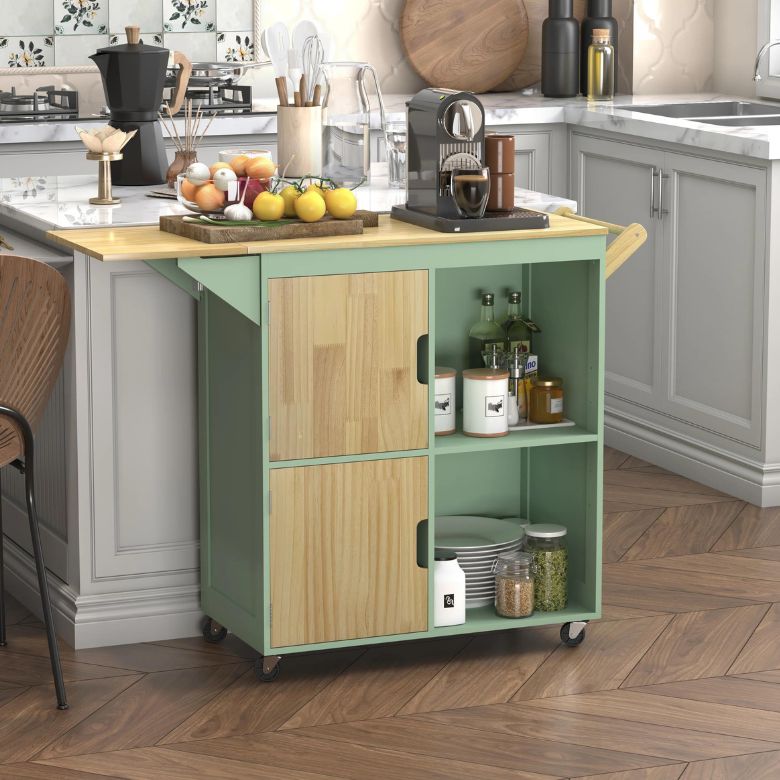 Green kitchen cart with wood accents holding jars, plates, and a coffee machine beside a countertop.